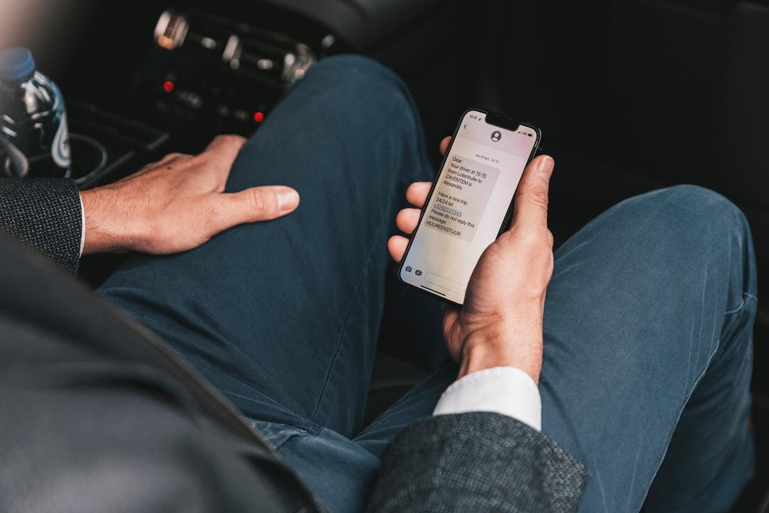Passagier ontvangt notificatie op smartphone met het bericht dat de chauffeur klaar staat.